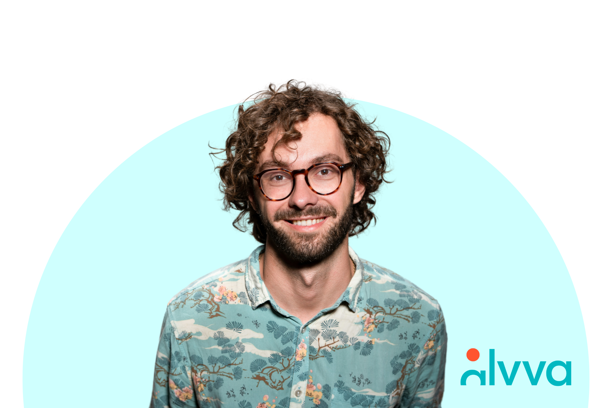 Un retrato de un hombre con gafas mirando directamente a la cámara y sonriendo